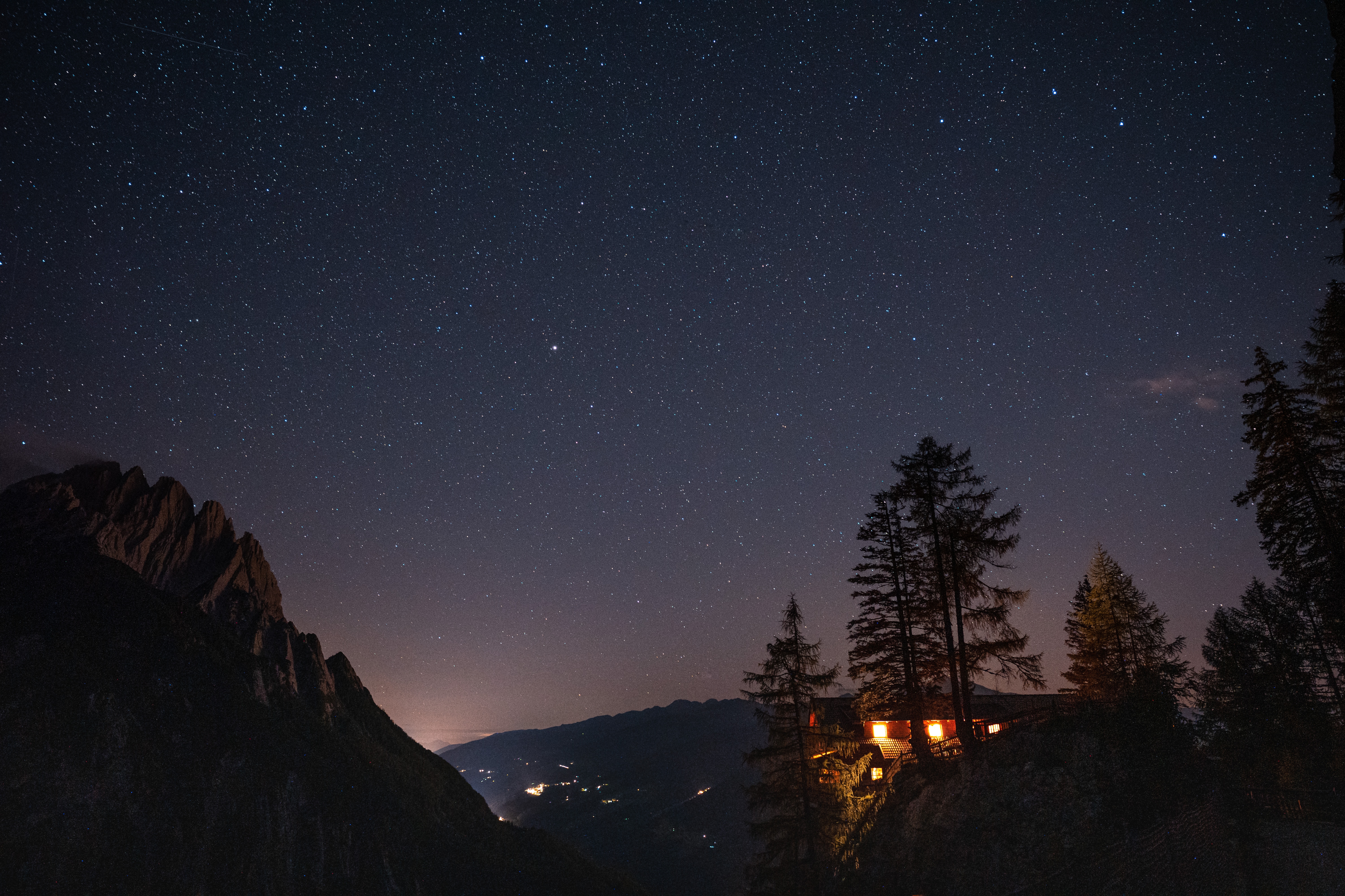 124751 download wallpaper mountains, night, dark, shine, light, starry sky, house, cliff screensavers and pictures for free