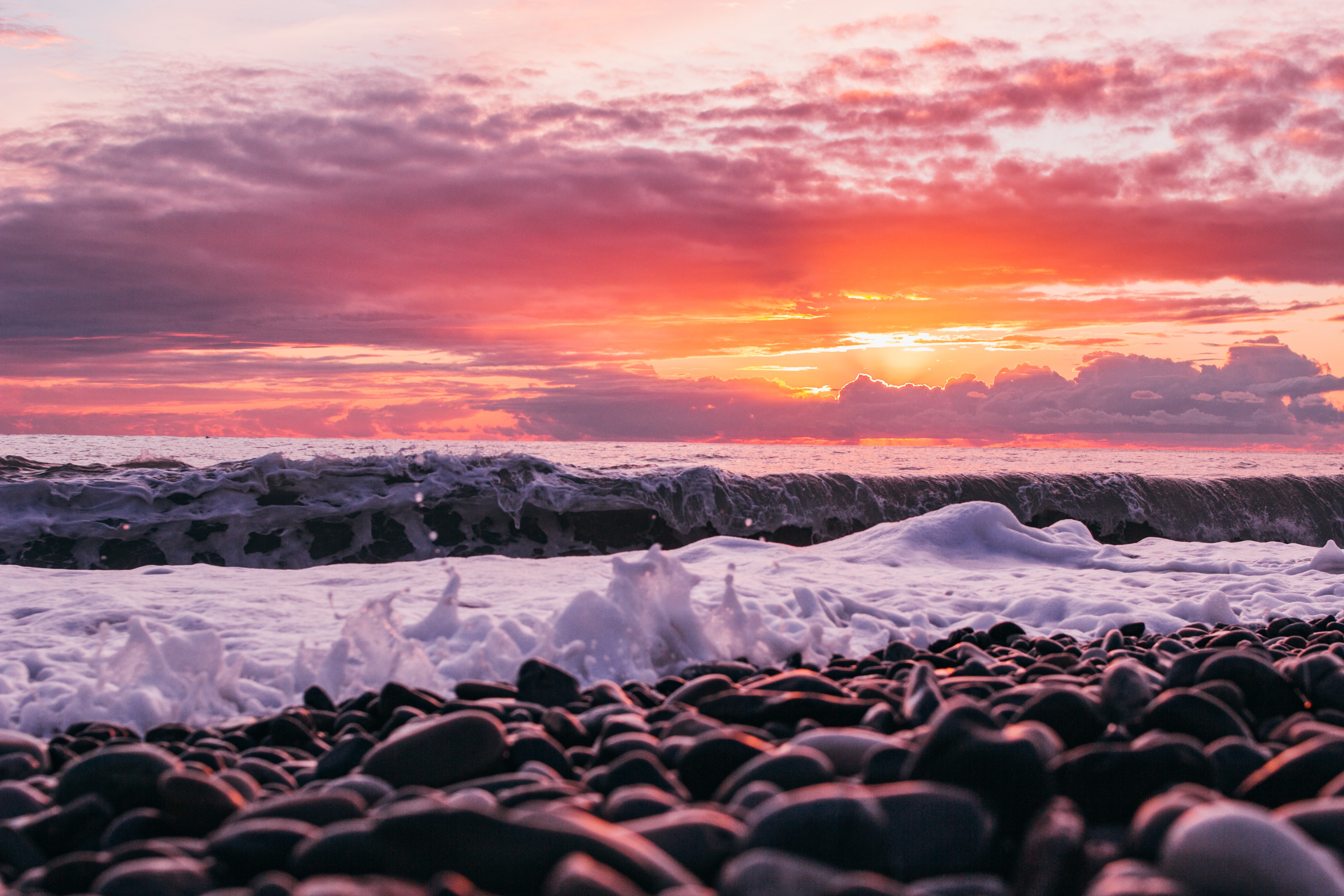 Sea sunset, bank, pebble, waves 1366x768 Wallpapers
