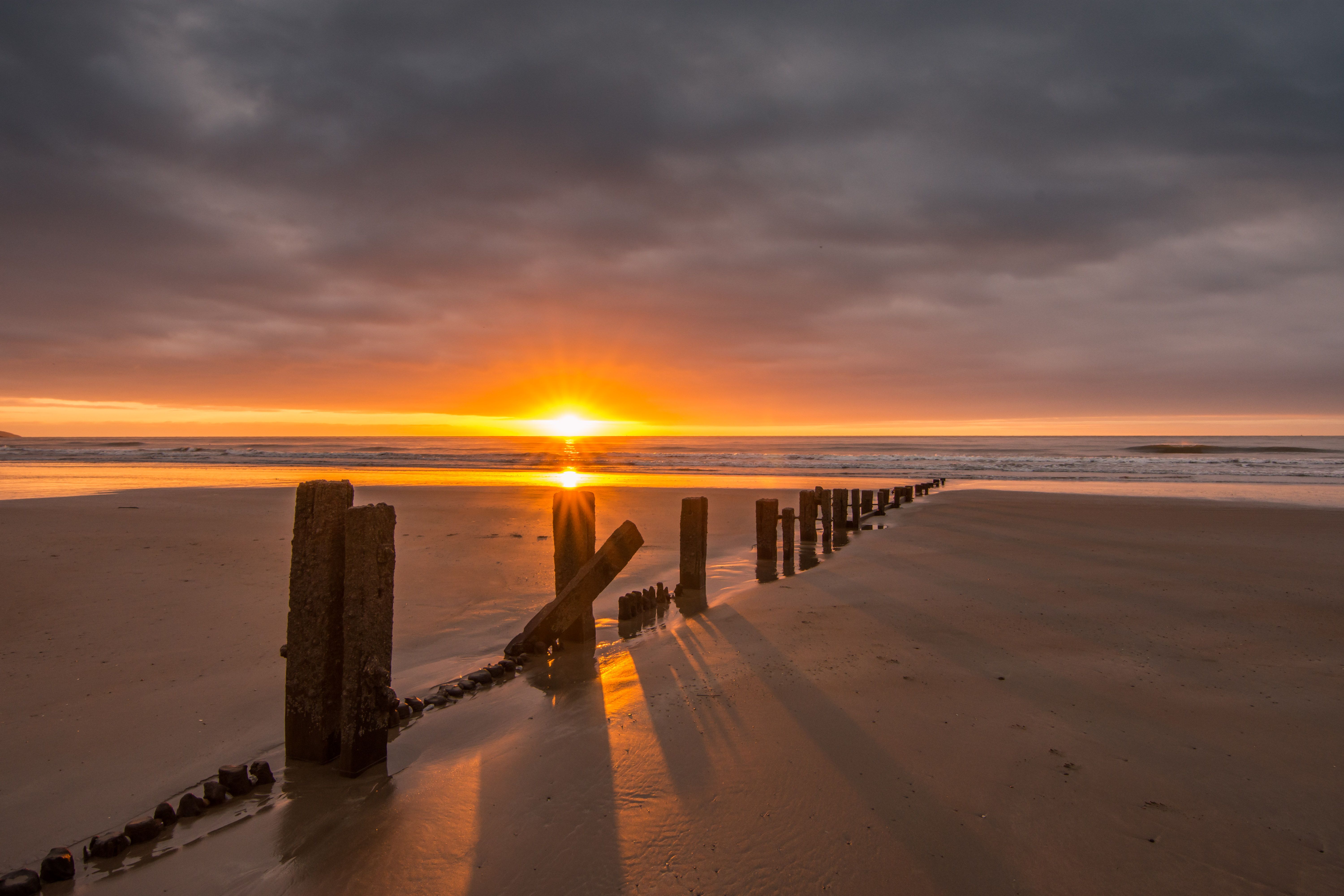sunset, beach, nature, sea, sand, pillars, posts Smartphone Background