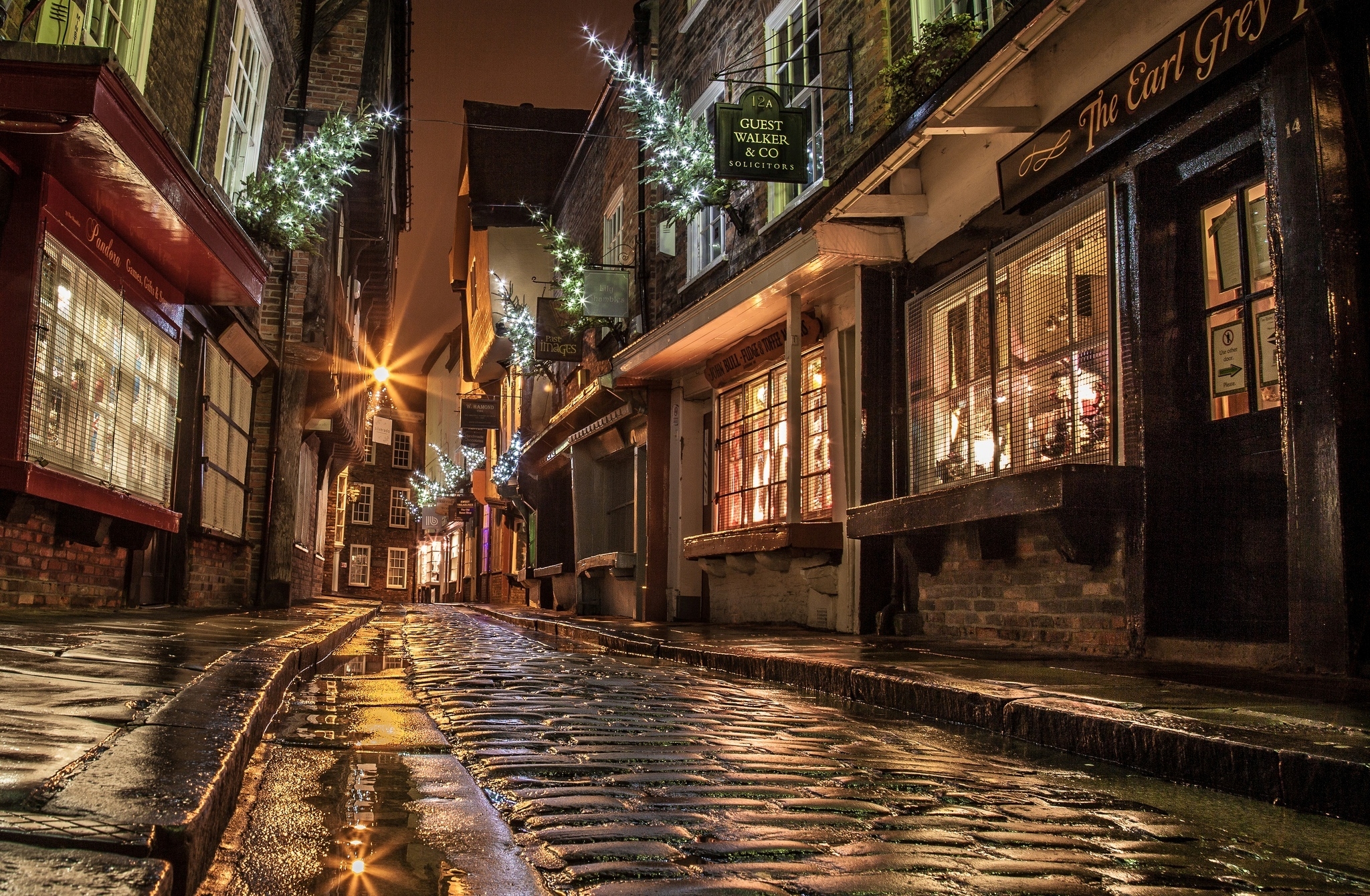 90205 download wallpaper houses, miscellaneous, miscellanea, light, windows, new year, night, shine, road, christmas, evening, street, shops, paving stones, sett, england screensavers and pictures for free