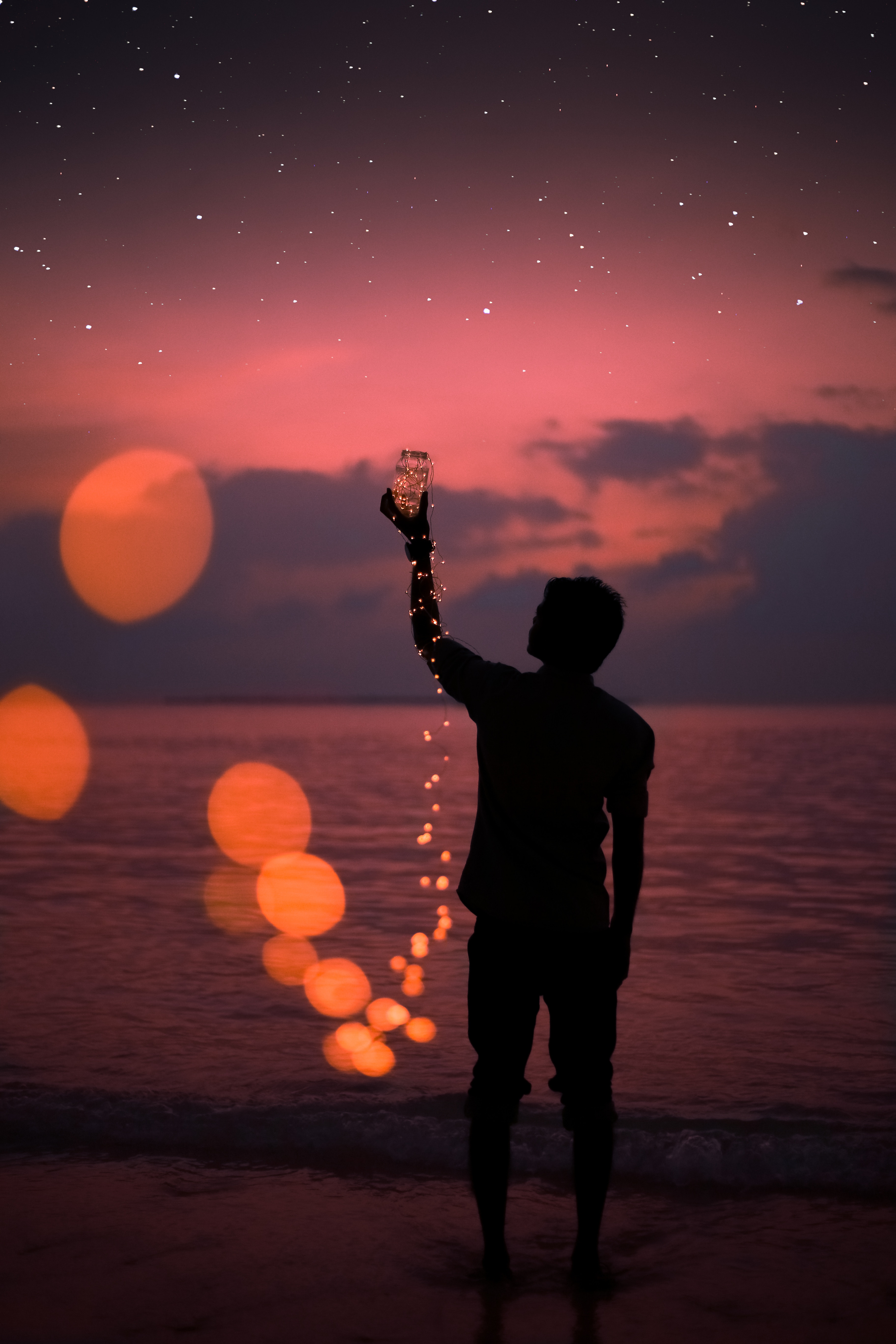 103461 download wallpaper human, dark, sea, stars, shore, bank, glare, silhouette, jar, person screensavers and pictures for free
