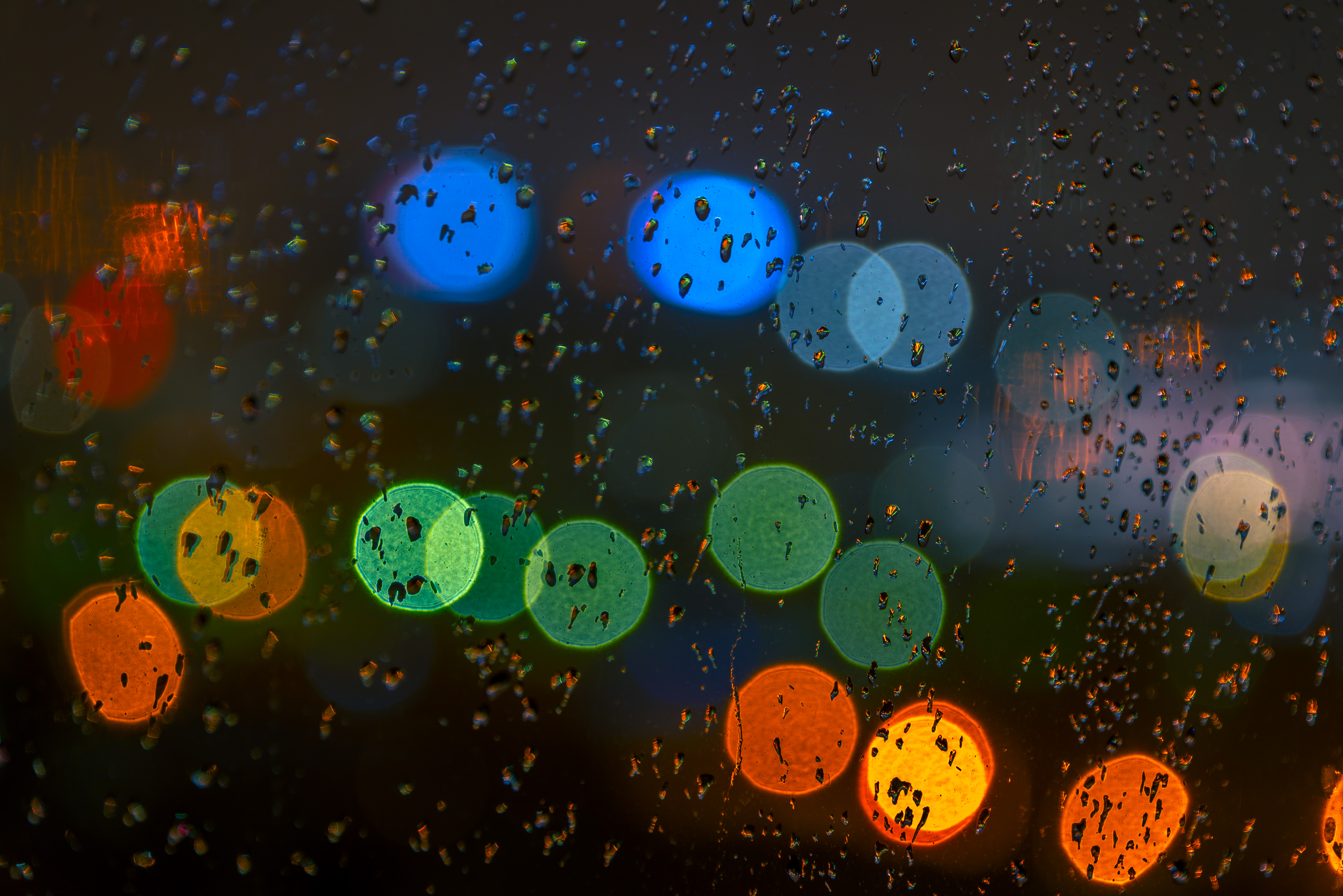 153571 download wallpaper rain, glass, drops, abstract, glare, multicolored, motley screensavers and pictures for free