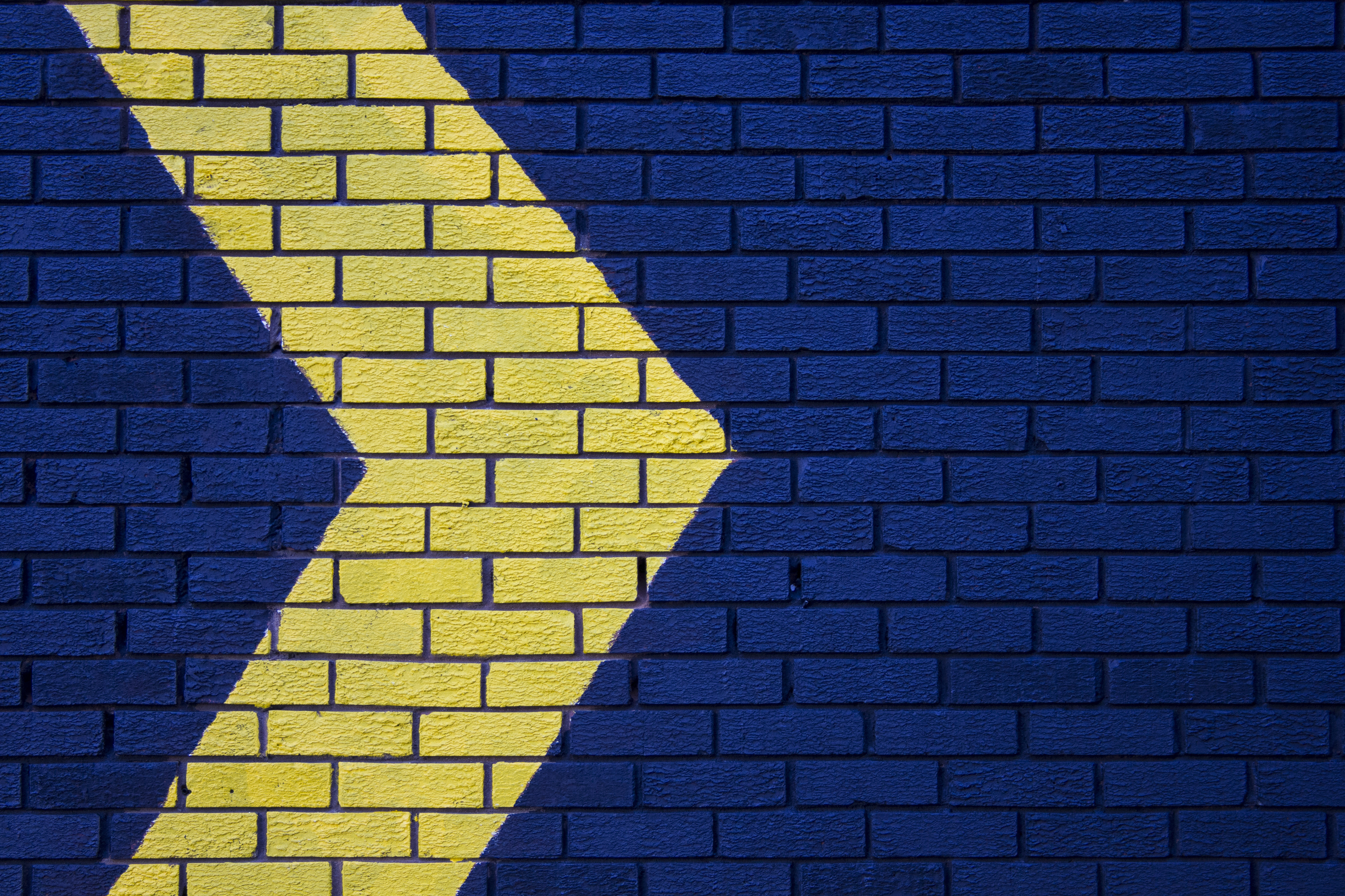 59364 download wallpaper texture, arrow, yellow, blue, textures, wall, pointer, direction, brick screensavers and pictures for free