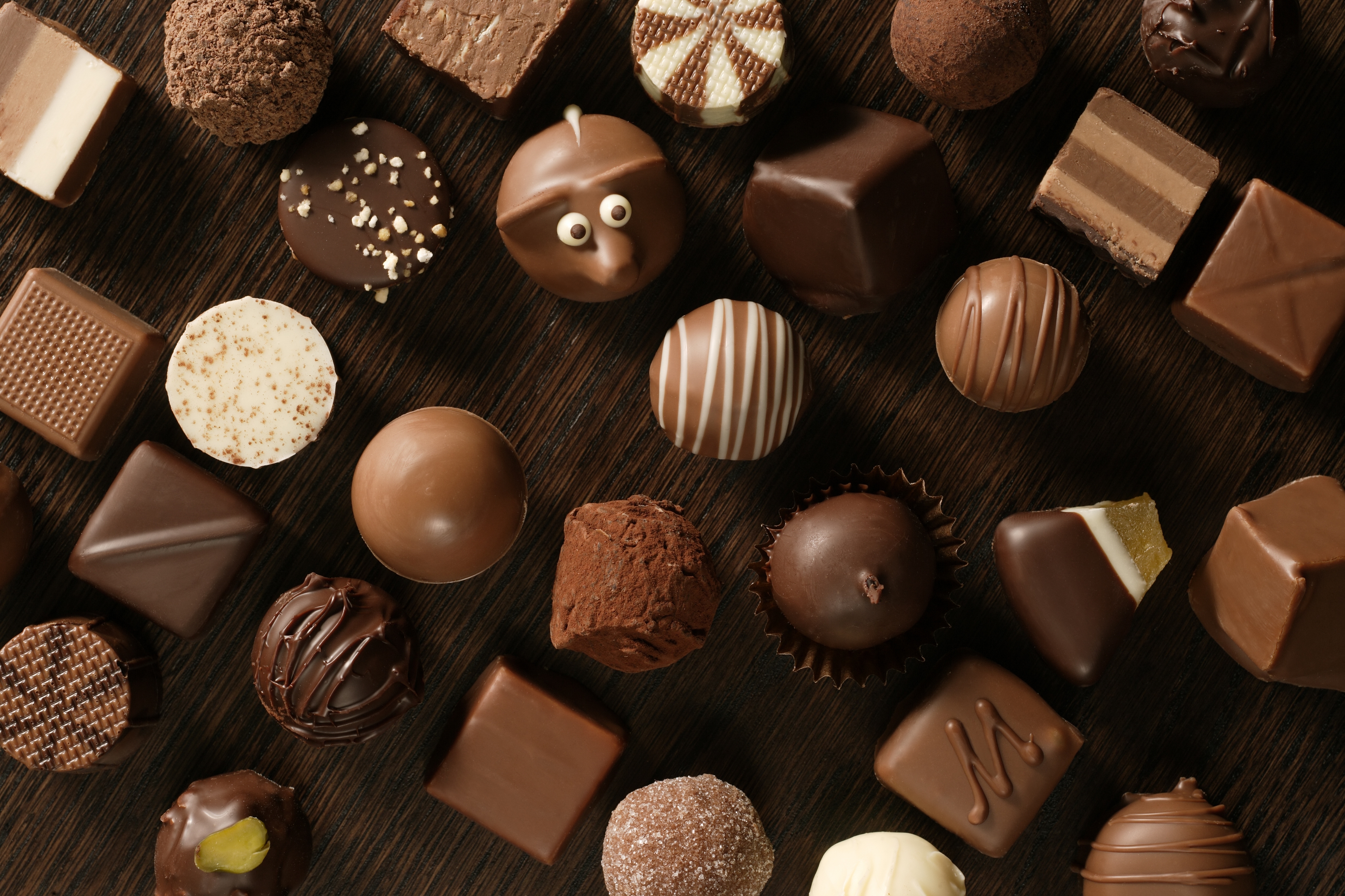 137180 download wallpaper chocolate, food, candies, eyes, table, assorted screensavers and pictures for free