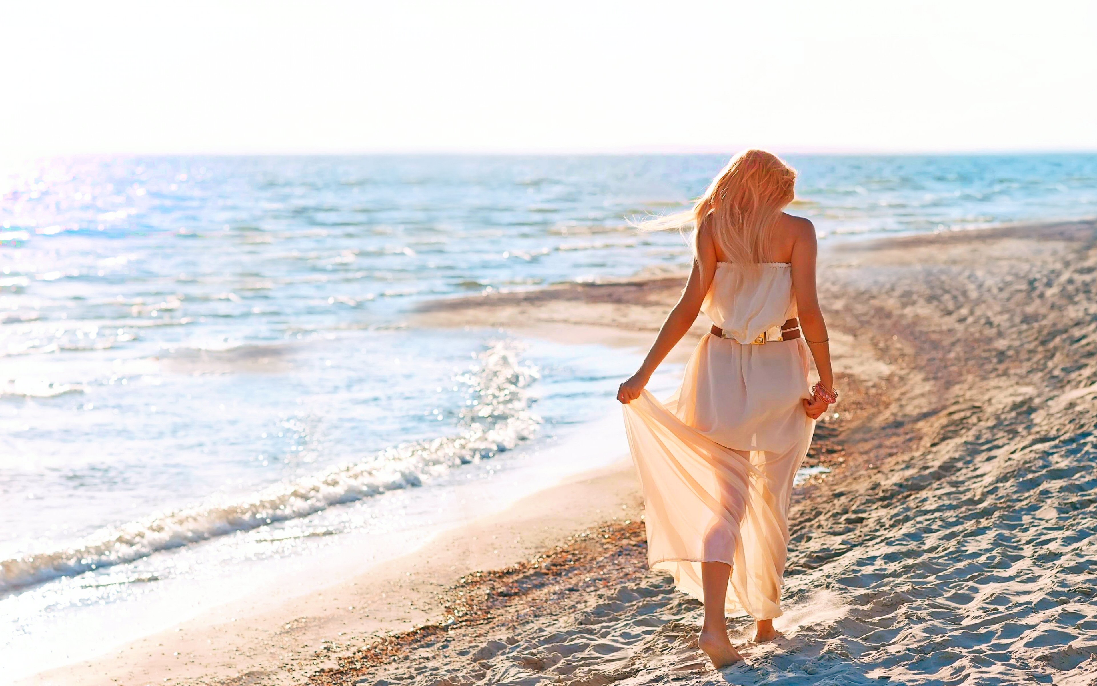 Блондинка на берегу моря спиной