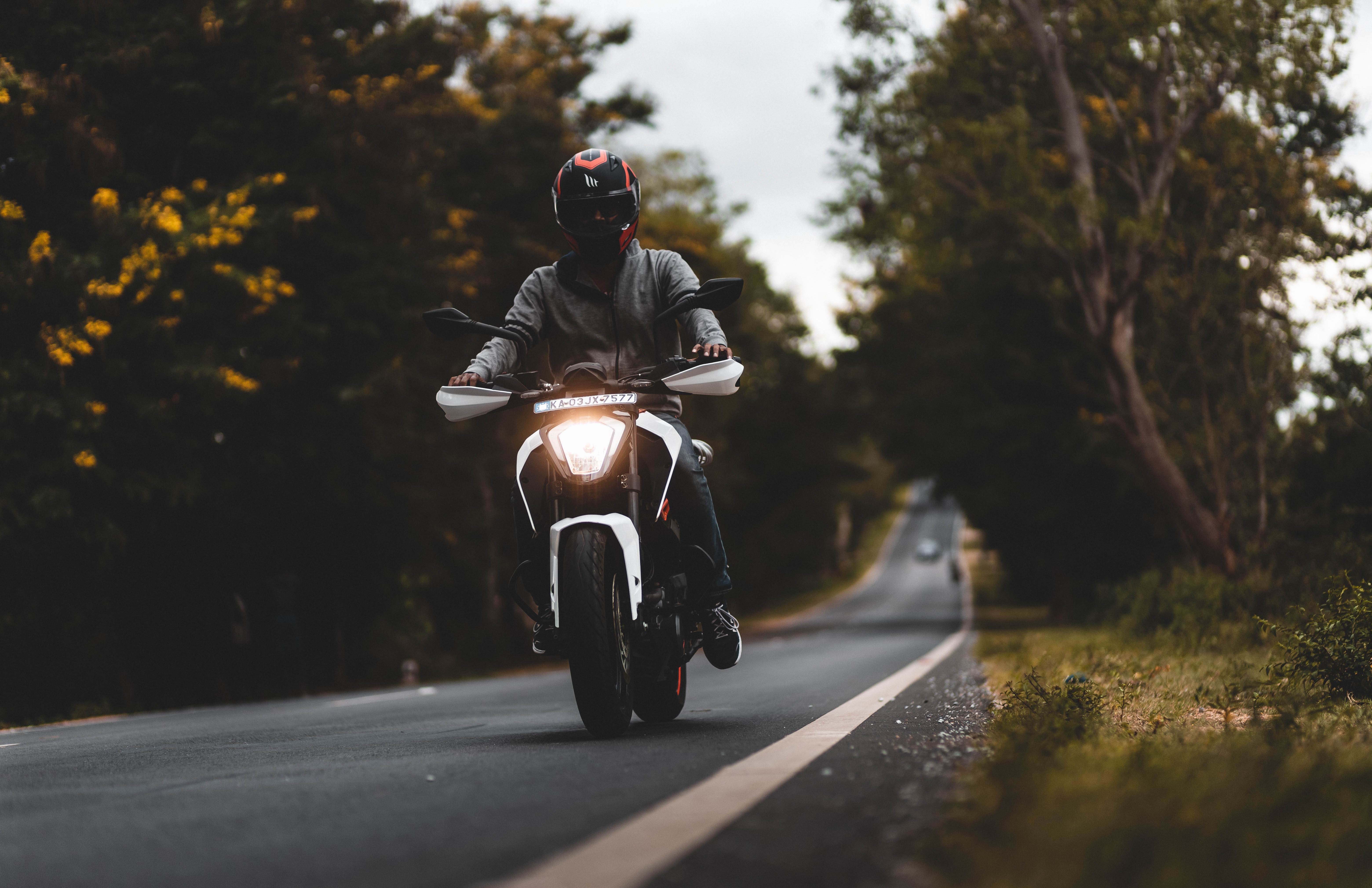 149112 Screensavers and Wallpapers Motorcyclist for phone. Download motorcyclist, trees, motorcycles, white, road, motorcycle pictures for free