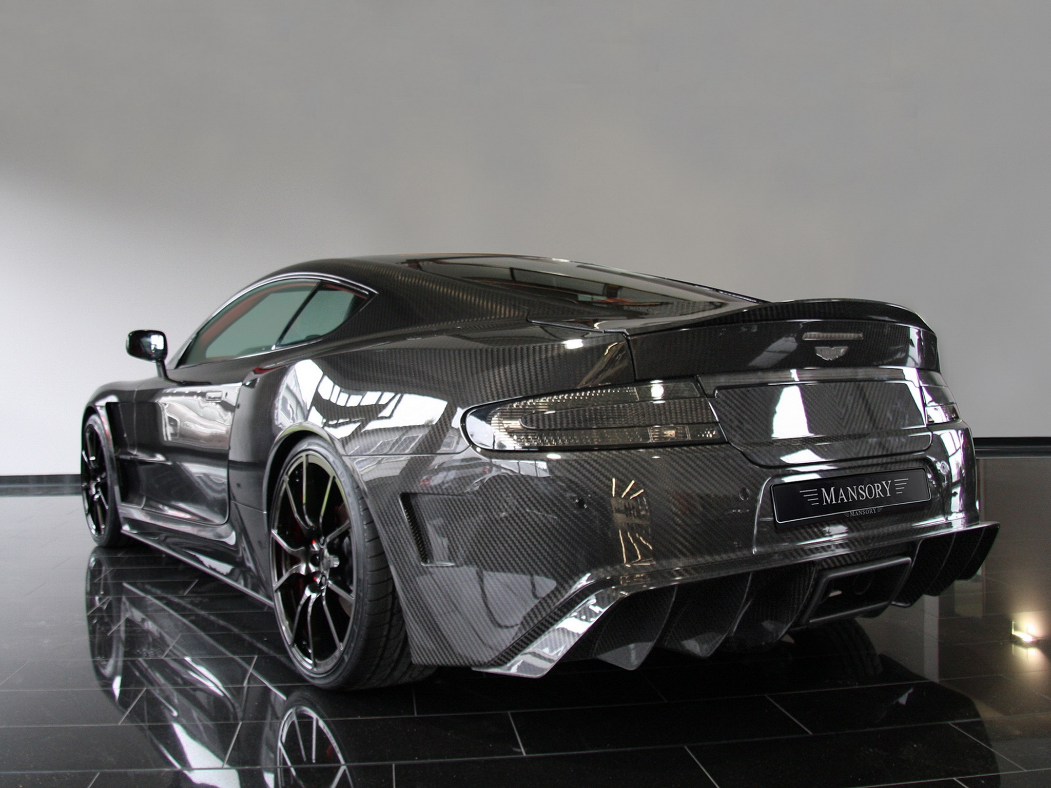 129885 download wallpaper aston martin, carbon, cars, black, reflection, back view, rear view, style, dbs, 2009, mansory screensavers and pictures for free